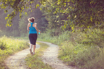 Image showing woman jogging along a country road