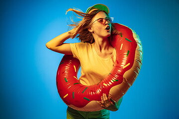 Image showing Beautiful woman in neon light isolated on blue studio background