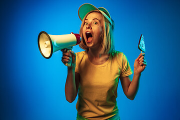 Image showing Beautiful woman in neon light isolated on blue studio background