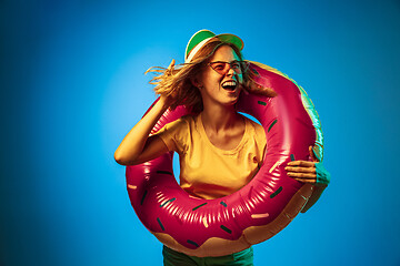 Image showing Beautiful woman in neon light isolated on blue studio background