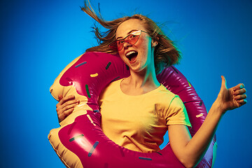 Image showing Beautiful woman in neon light isolated on blue studio background