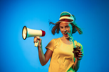 Image showing Beautiful woman in neon light isolated on blue studio background