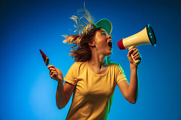 Image showing Beautiful woman in neon light isolated on blue studio background