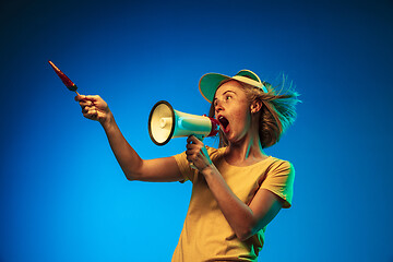 Image showing Beautiful woman in neon light isolated on blue studio background