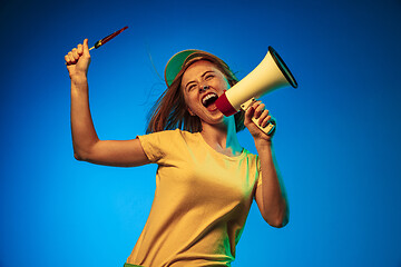 Image showing Beautiful woman in neon light isolated on blue studio background