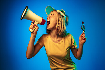 Image showing Beautiful woman in neon light isolated on blue studio background