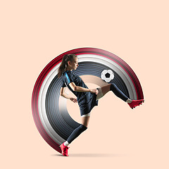 Image showing Female soccer or football player kicking ball