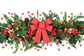 Image showing Winter Greenery with Holly and Red Glitter Bow 