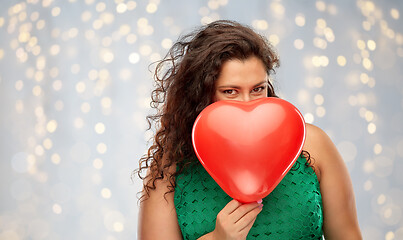 Image showing playful woman holding red heart shaped balloon