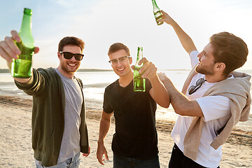 Image showing young men toasting non alcoholic beer on beach