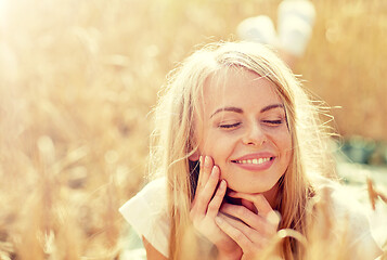 Image showing happy woman or teen girl lying in cereal field