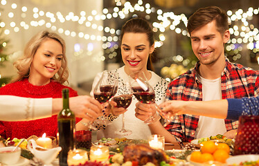 Image showing happy friends drinking red wine at christmas party