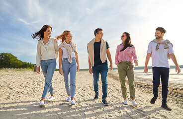 Image showing happy friends walking along summer beach