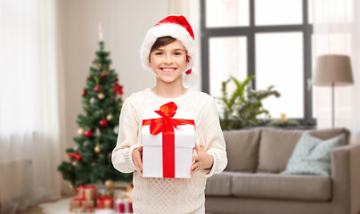 Image showing happy boy in santa hat with christmas gift at home