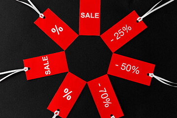 Image showing red tags with discount signs on black background