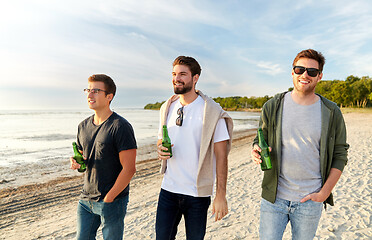 Image showing young men with non alcoholic beer walking on beach