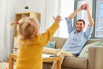 Image showing father and baby daughter playing with ball at home