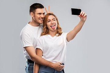 Image showing happy couple in white t-shirts taking selfie