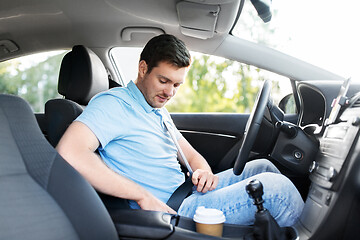 Image showing man or car driver fastening seat belt