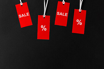 Image showing red tags with discount signs on black background