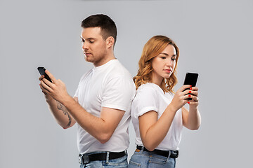 Image showing couple in white t-shirts with smartphones