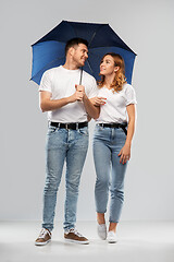 Image showing happy couple in white t-shirts with umbrella