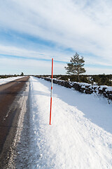 Image showing Country road with a red snow stake by roadside