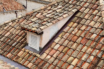 Image showing An old tiled roof of a European house with a dormer