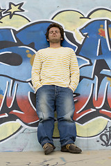 Image showing Man next to a graffiti wall