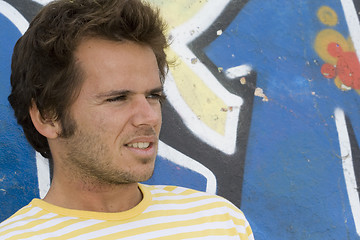 Image showing Man next to a graffiti wall