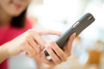 Image showing Woman browsing mobile phone in cafe