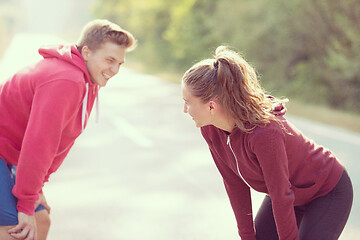 Image showing young couple warming up and stretching on a country road