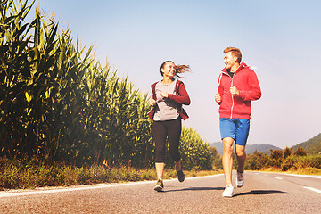 Image showing young couple jogging along a country road