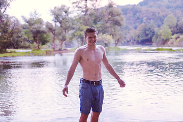 Image showing man with a bare torso splashing water