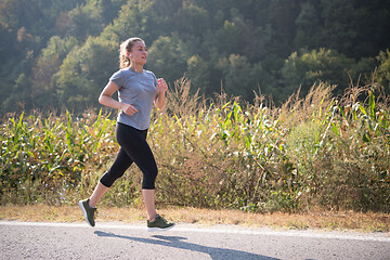 Image showing woman jogging along a country road