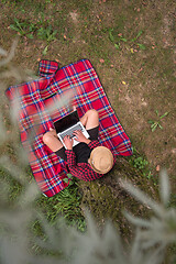 Image showing top view of man using a laptop computer under the tree