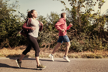 Image showing young couple jogging along a country road