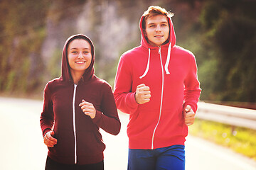 Image showing young couple jogging along a country road