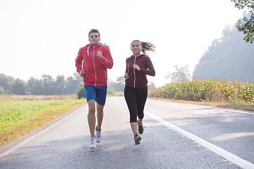 Image showing young couple jogging along a country road