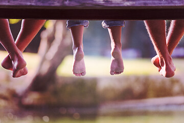 Image showing people sitting at wooden bridge