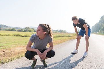 Image showing young couple warming up and stretching on a country road