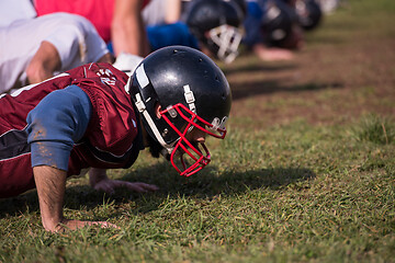 Image showing american football team doing push ups