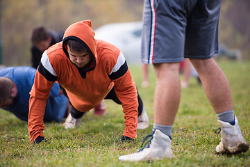 Image showing american football team doing push ups