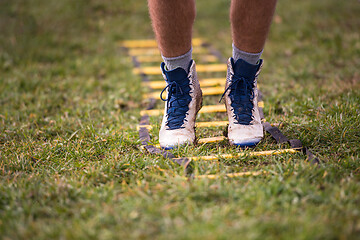 Image showing american football player exercises on ladder drills