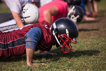 Image showing american football team doing push ups