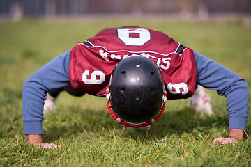 Image showing american football player doing push ups