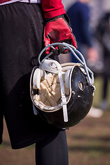 Image showing American football player holding helmet