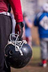 Image showing American football player holding helmet