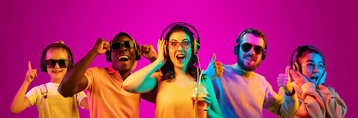 Image showing Beautiful young people in neon light isolated on pink studio background