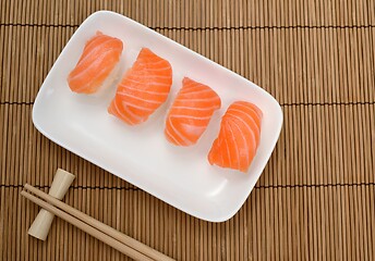Image showing chopsticks and sushi with salmon on the mat